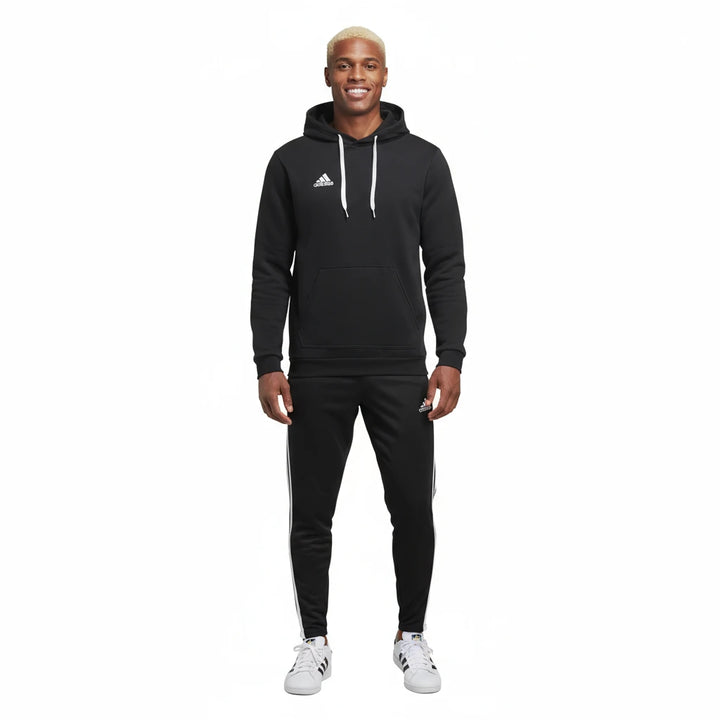 Person wearing a black Adidas tracksuit on a white background