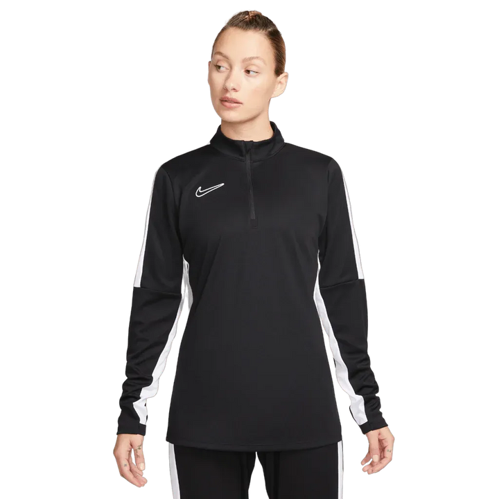 Woman in black Nike Academy Pro Jacket with white sleeve panels, standing straight