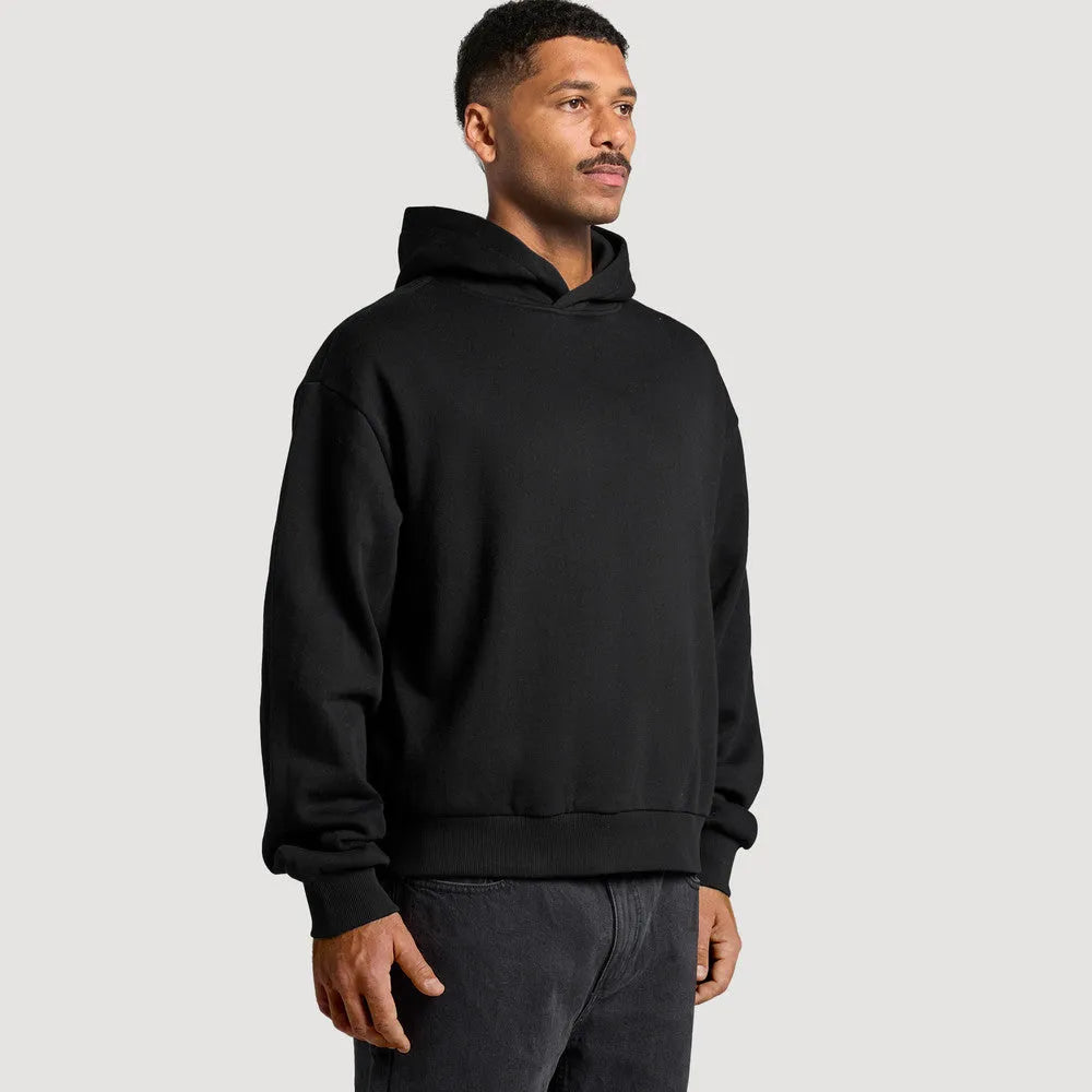 Side profile of model in black oversized boxy hoodie