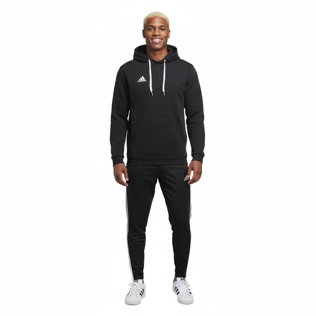 Person wearing a black Adidas tracksuit on a white background