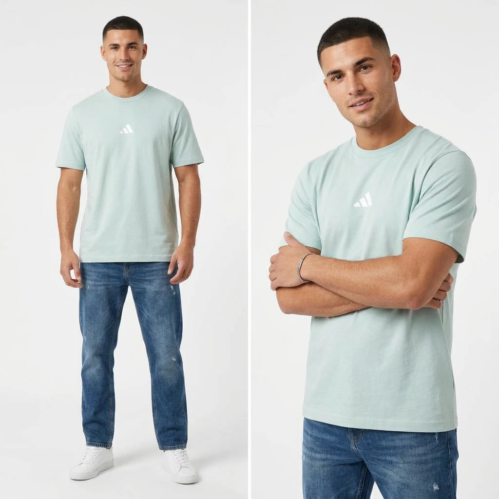 Man wearing a light blue t-shirt with a logo and jeans on a white background