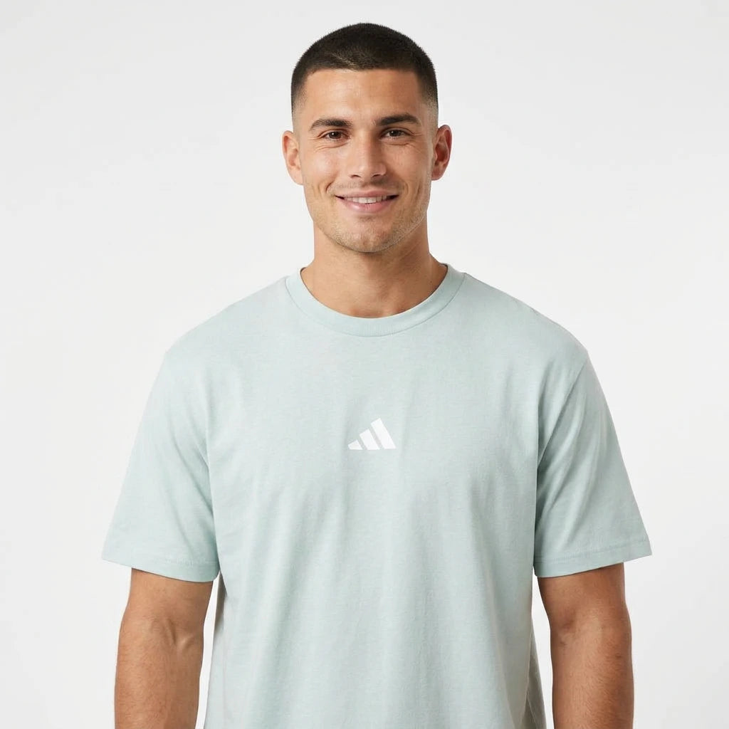 Man wearing a light blue Adidas t-shirt on a white background