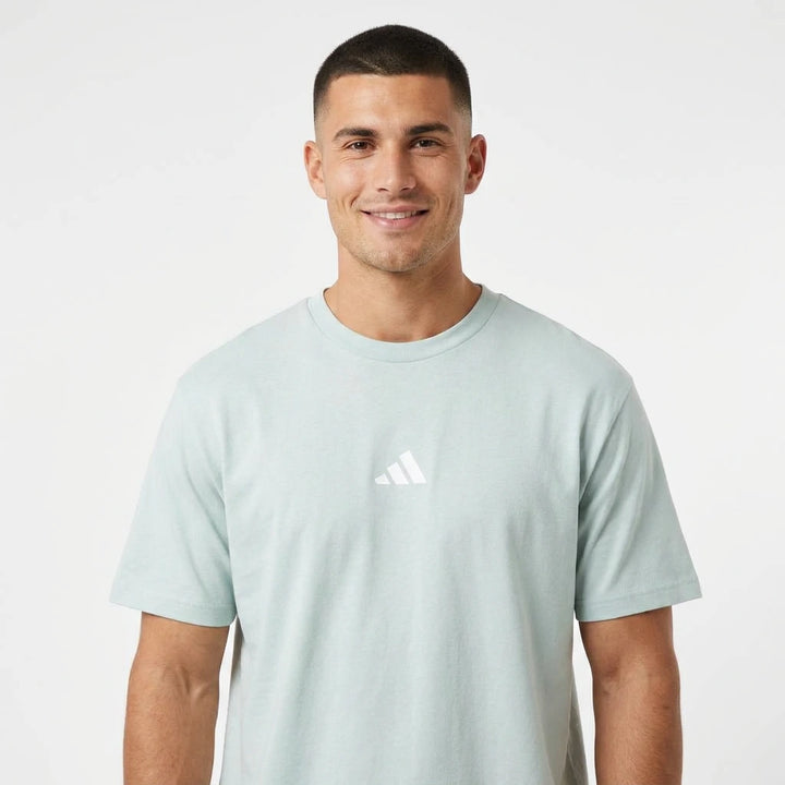 Man wearing a light blue Adidas t-shirt on a white background