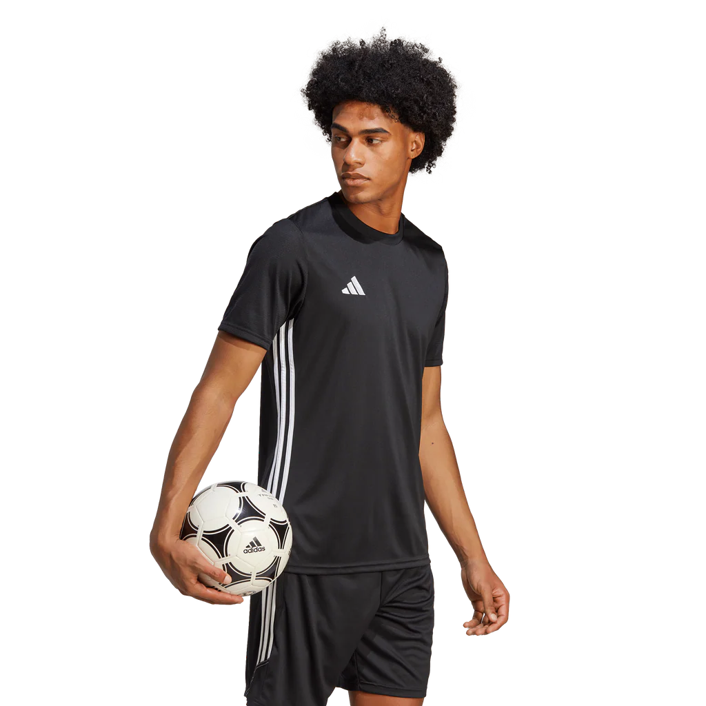 Person wearing an Adidas black sports outfit holding a soccer ball on a white background