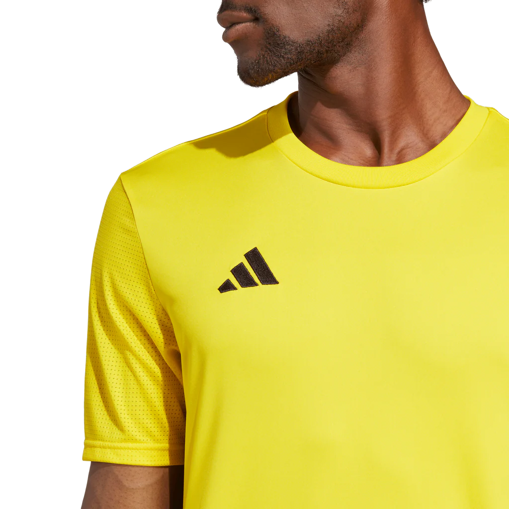 Yellow Adidas shirt worn by a person on a white background