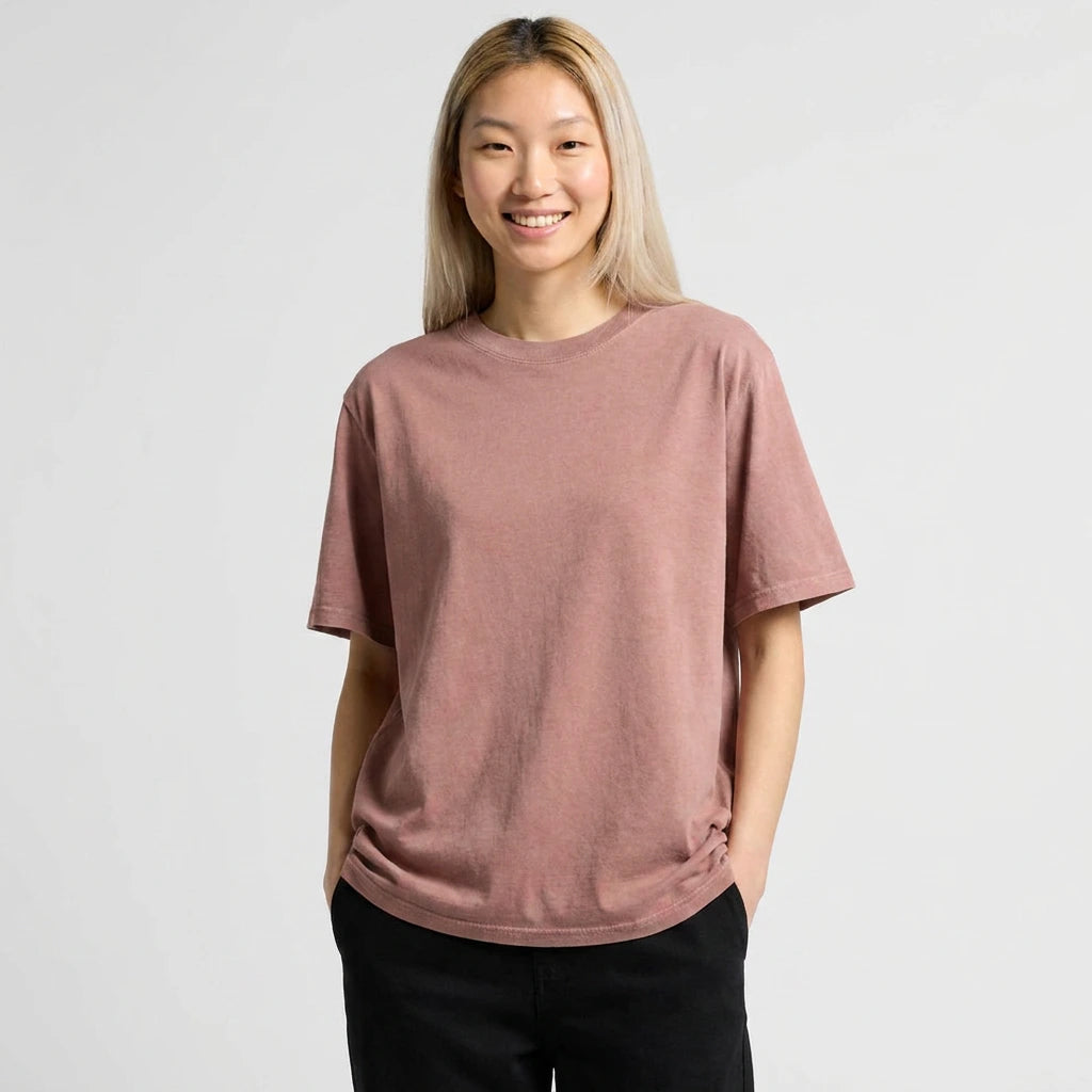 Person wearing a loose-fitting pink t-shirt against a plain background