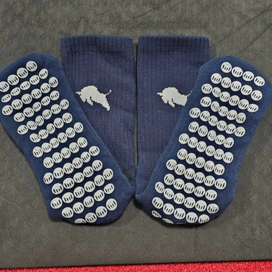 Pair of blue El Toro socks with white textured sole pattern on a gray background