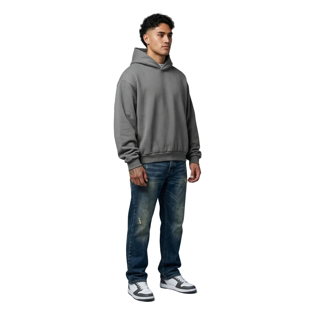 Man wearing a gray hoodie and blue jeans on a gray background