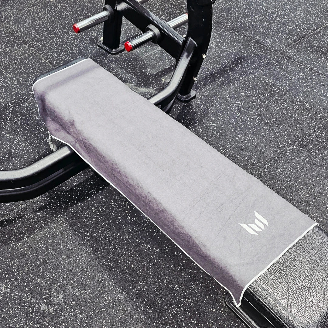 Gray gym bench with a logo on a textured floor