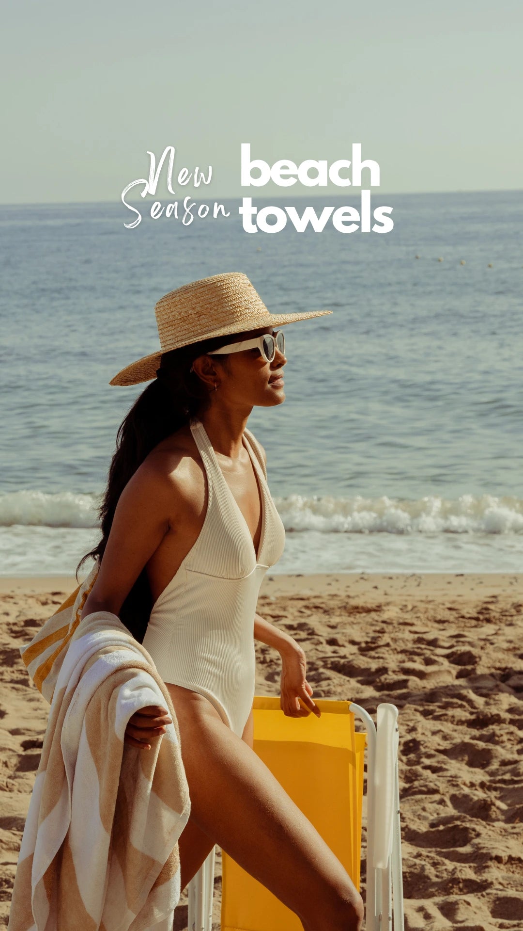 An female model in a bikini with an Empulse beach towel resting on her hand