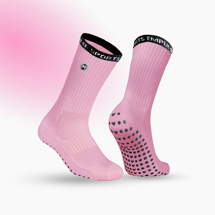 Pink socks with black grip dots and a visible brand logo on a pink background