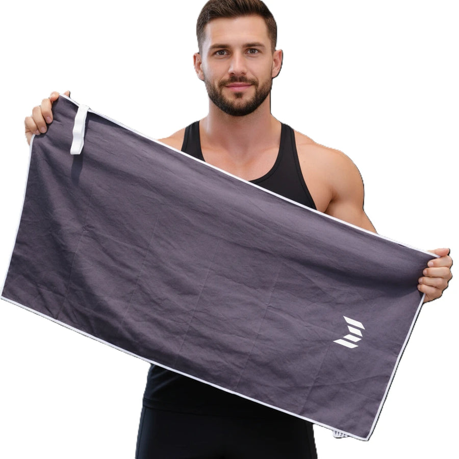 Man holding Empulse Blackout gym towel after training session