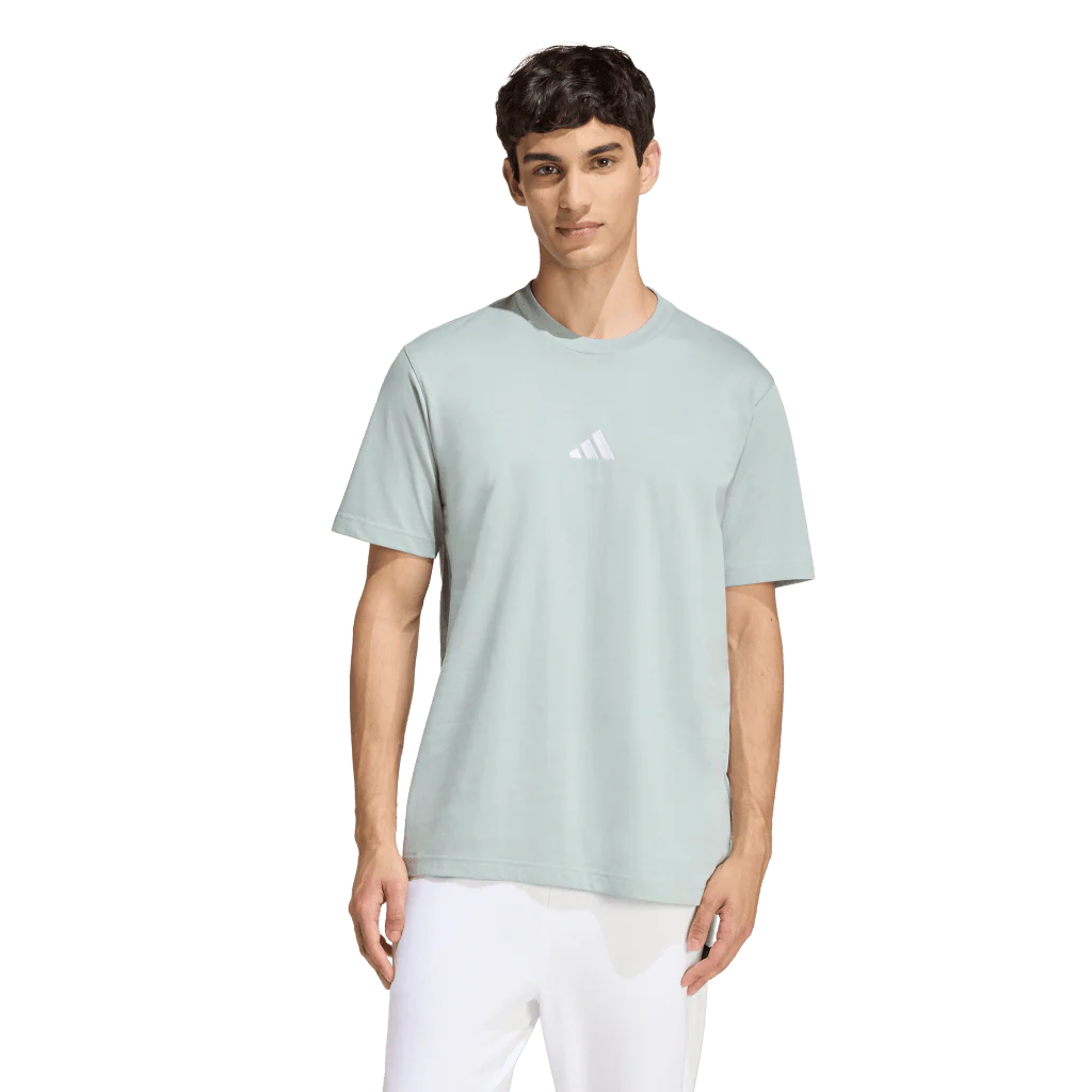 Person wearing a light green Adidas t-shirt on a white background