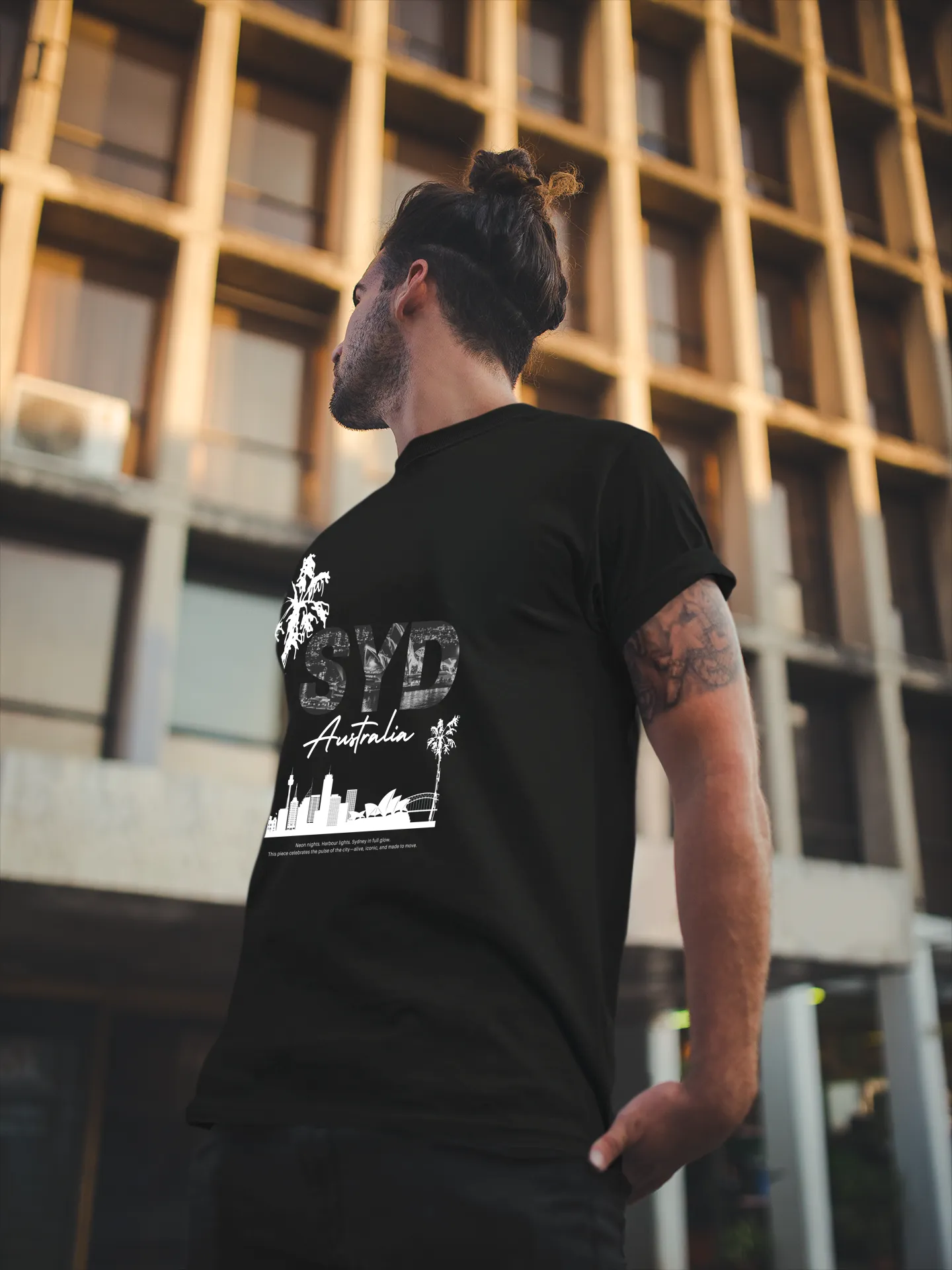 Man looking up while wearing Empulse™ Sydney black tshirt with white skyline and palm tree design