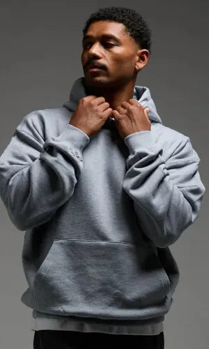 Man wearing a gray hoodie against a gray background