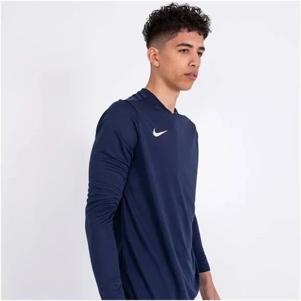 Side profile of male model wearing Nike Dri-FIT Park VII long sleeve t-shirt in navy with white swoosh.