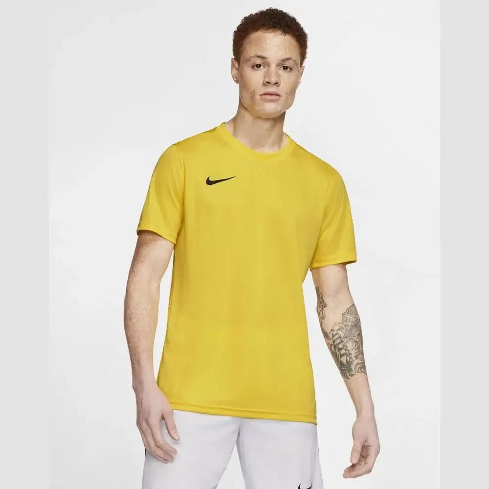 Full body view of male model wearing yellow Nike Park 7 Jersey with white shorts and shoes