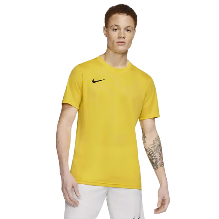 Full body view of male model wearing yellow Nike Park 7 Jersey with white shorts and shoes