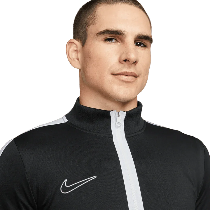 Man wearing a black Nike tracksuit on a white background