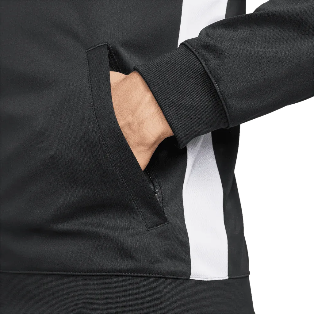 Close-up of a black and white jacket with a hand in the pocket on a white background