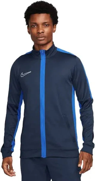 Man wearing a navy and blue Nike tracksuit on a white background