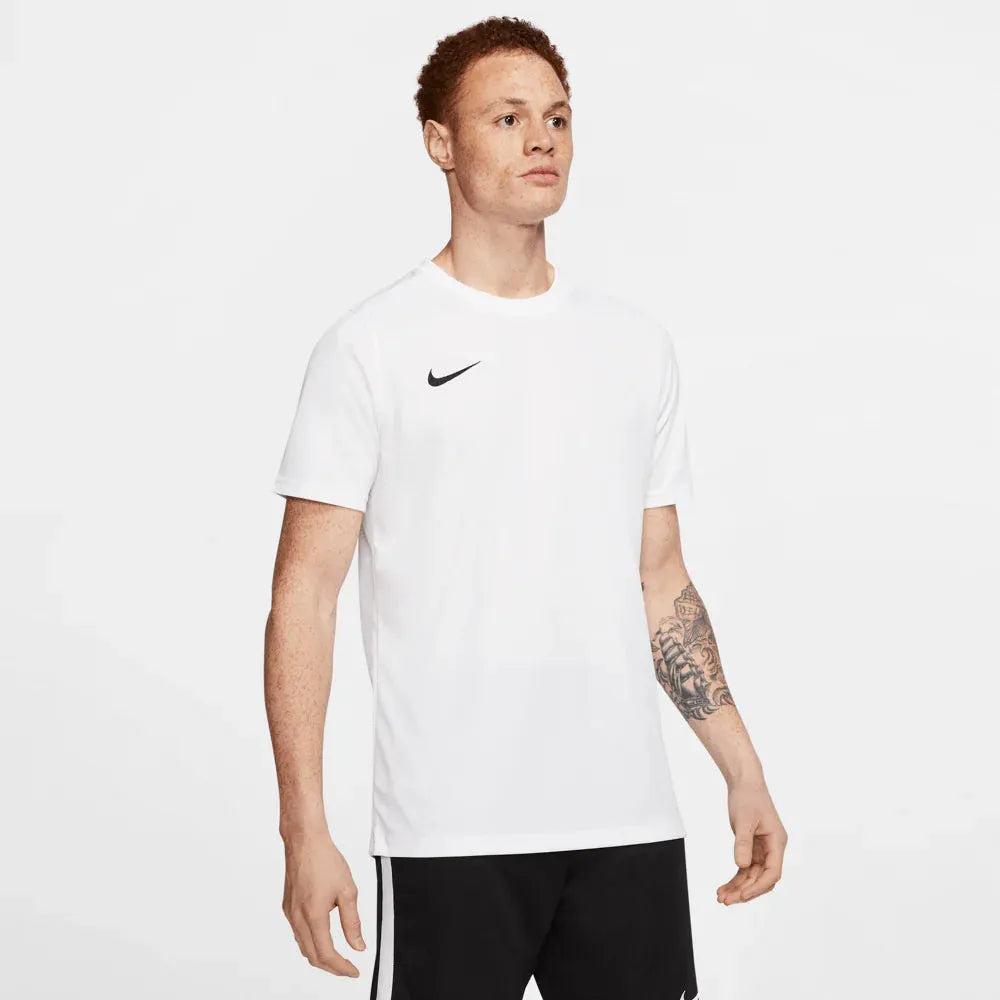 Male model wearing Nike Park 7 Jersey in white with relaxed posture and tattoos visible