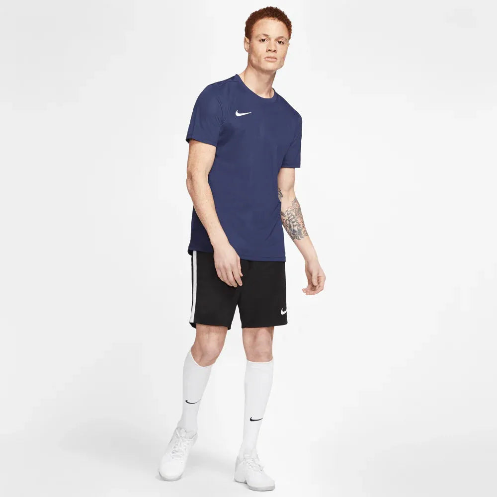 Full body view of model in navy Nike Park 7 Jersey paired with black shorts and white socks