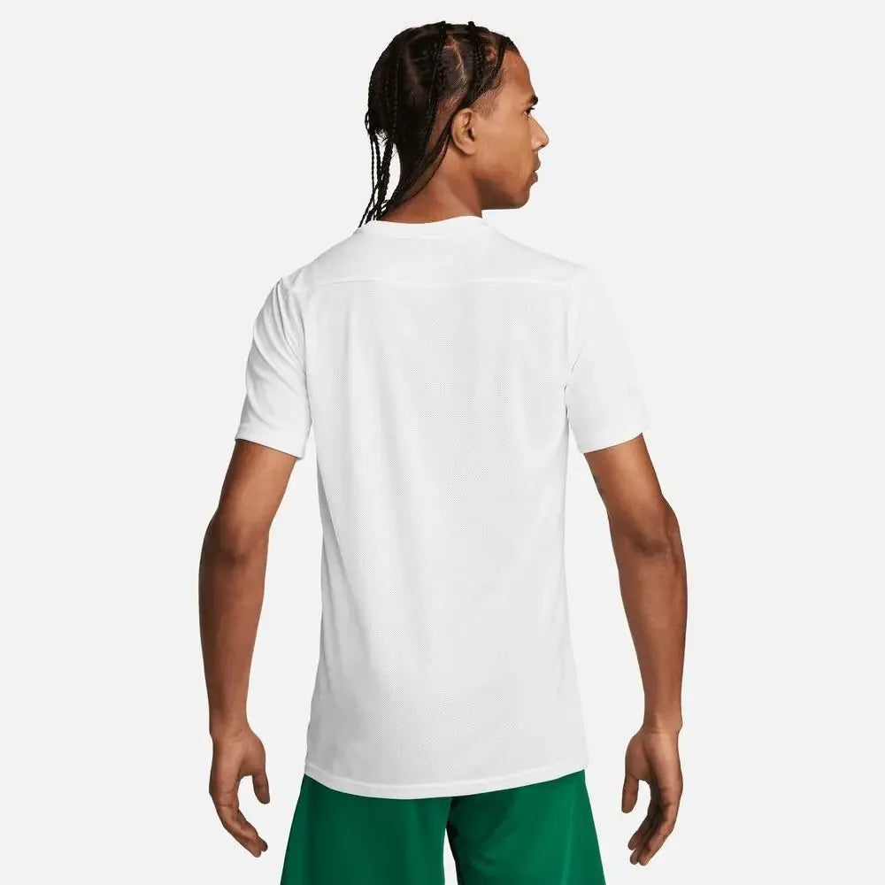 Side-back view of model in white Nike Park 7 Jersey paired with green shorts