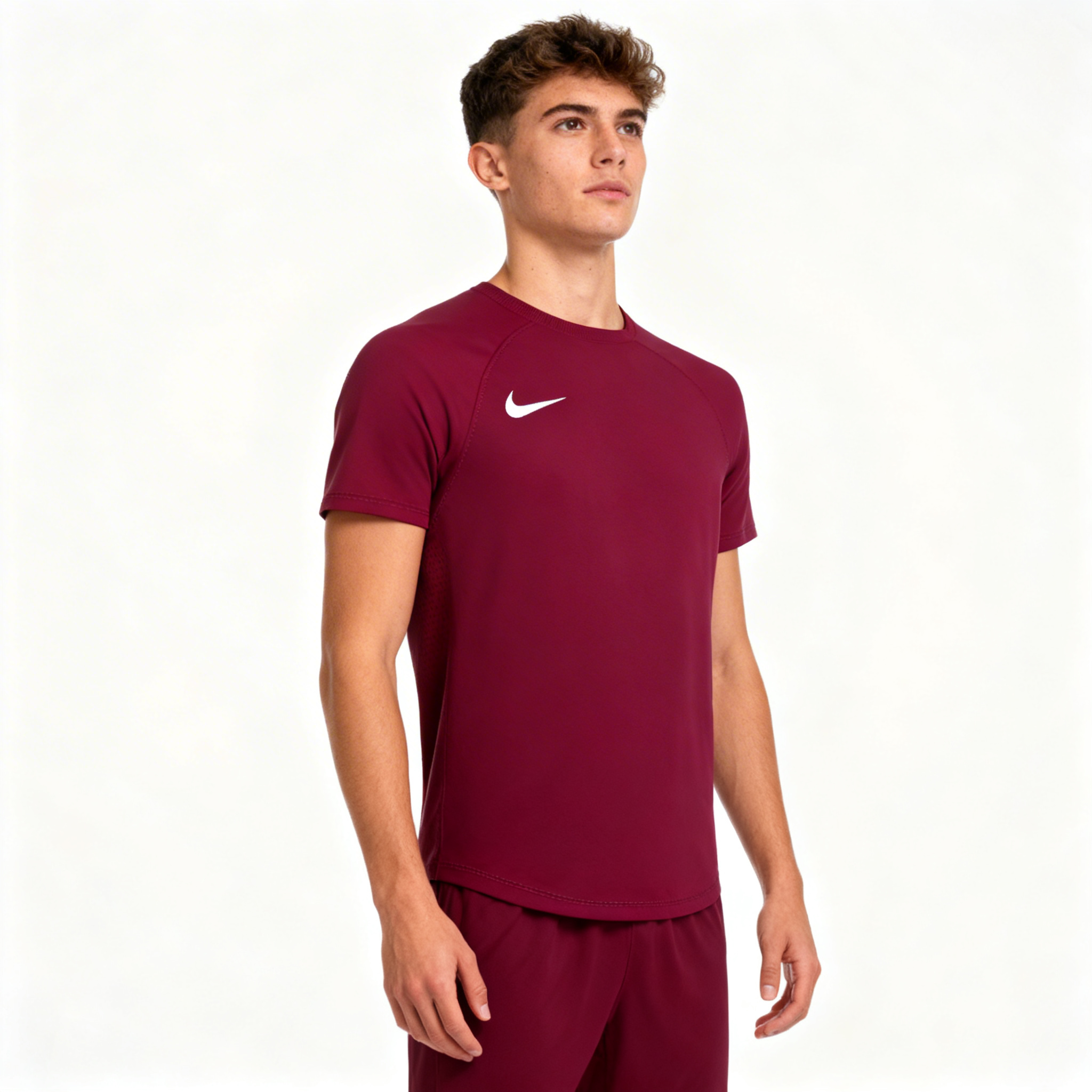 Person wearing a maroon Nike athletic outfit on a white background