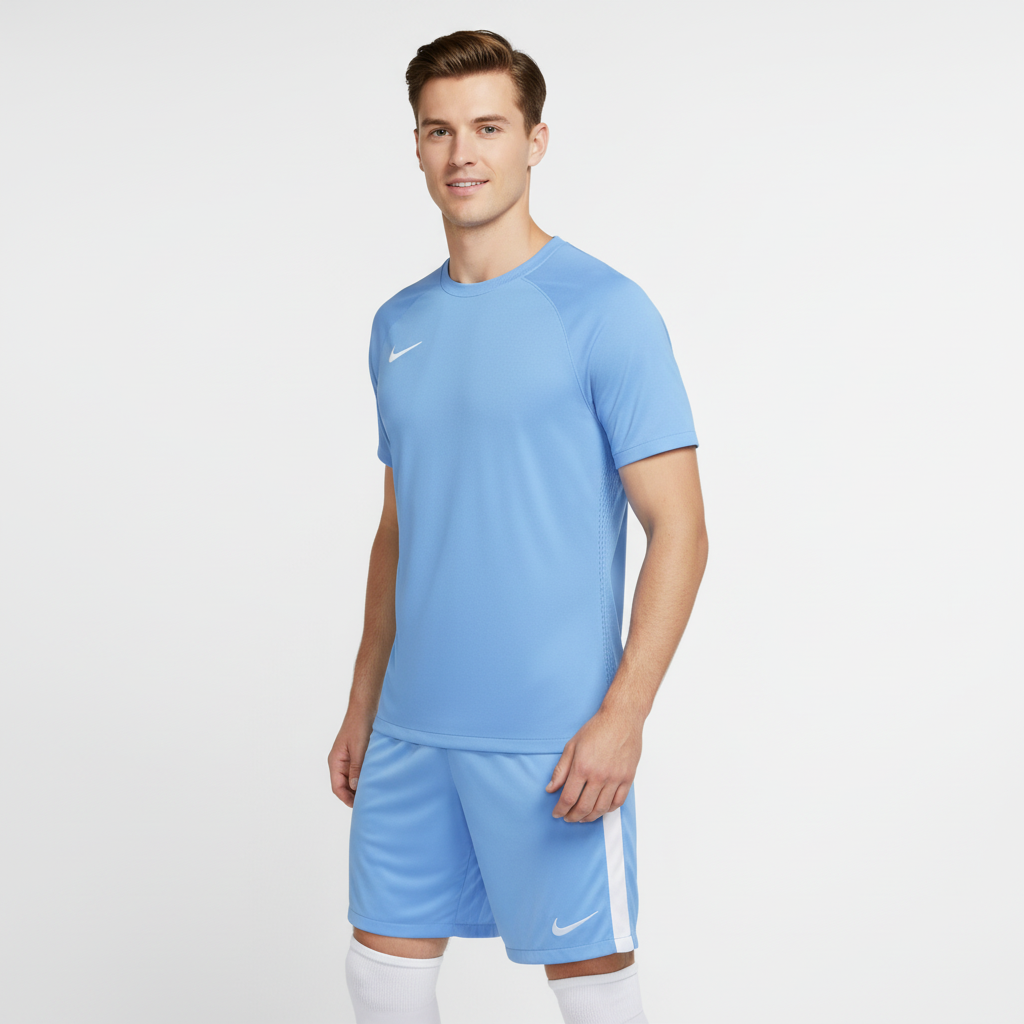 Man wearing a light blue Nike soccer jersey and shorts on a white background