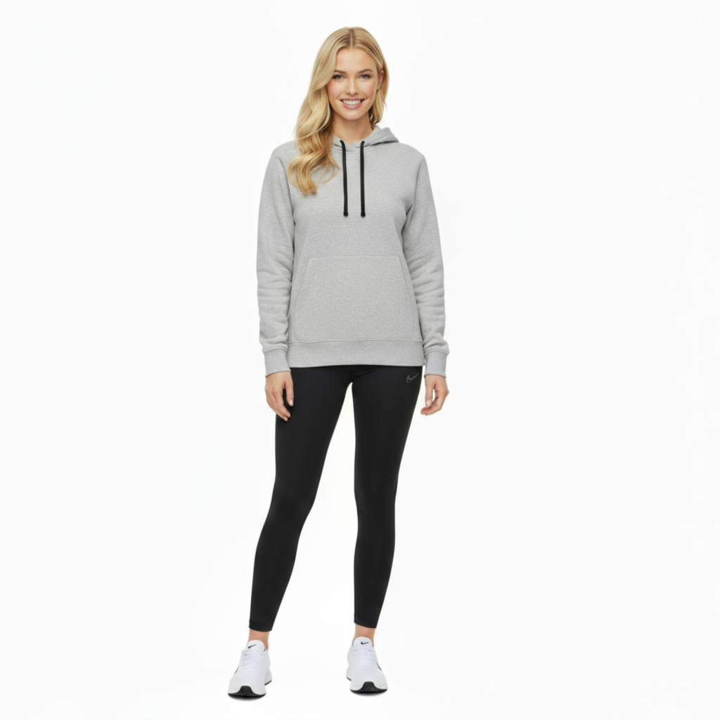 Woman wearing a gray Nike Park 20 hoodie and black leggings on a white background