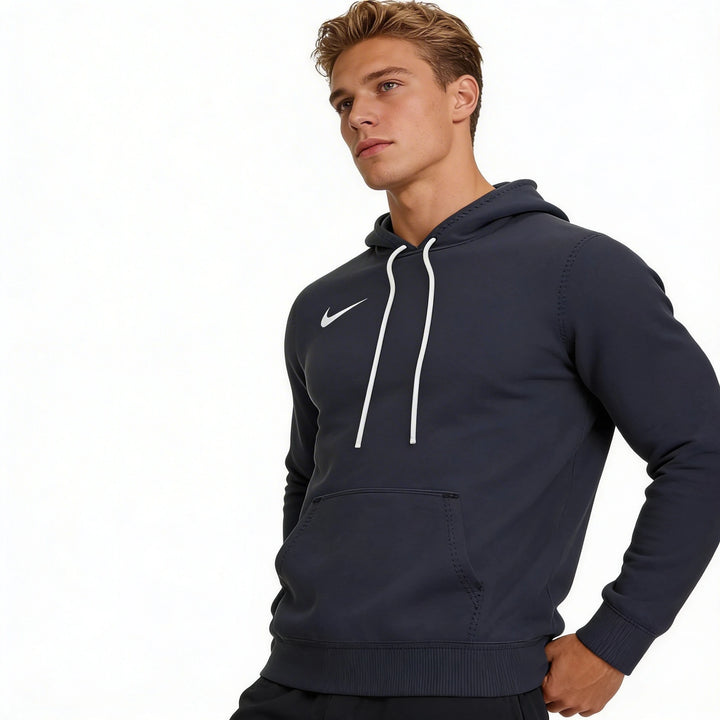 Man wearing a Nike navy blue hoodie with a white logo on a white background
