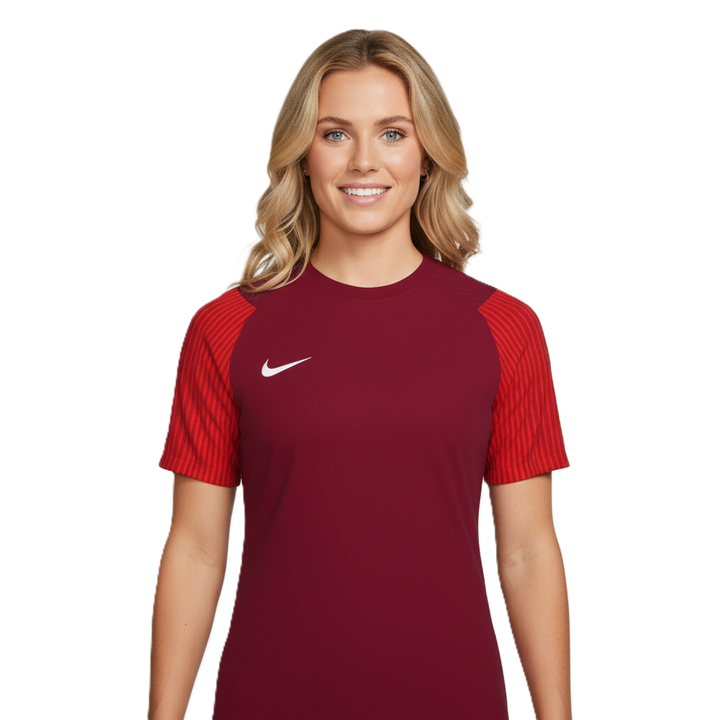 Woman wearing a maroon sports jersey with red sleeves on a white background