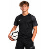 Youth player wearing the black Nike Academy 2 Youth Jersey with patterned grey sleeves, front view, holding a football