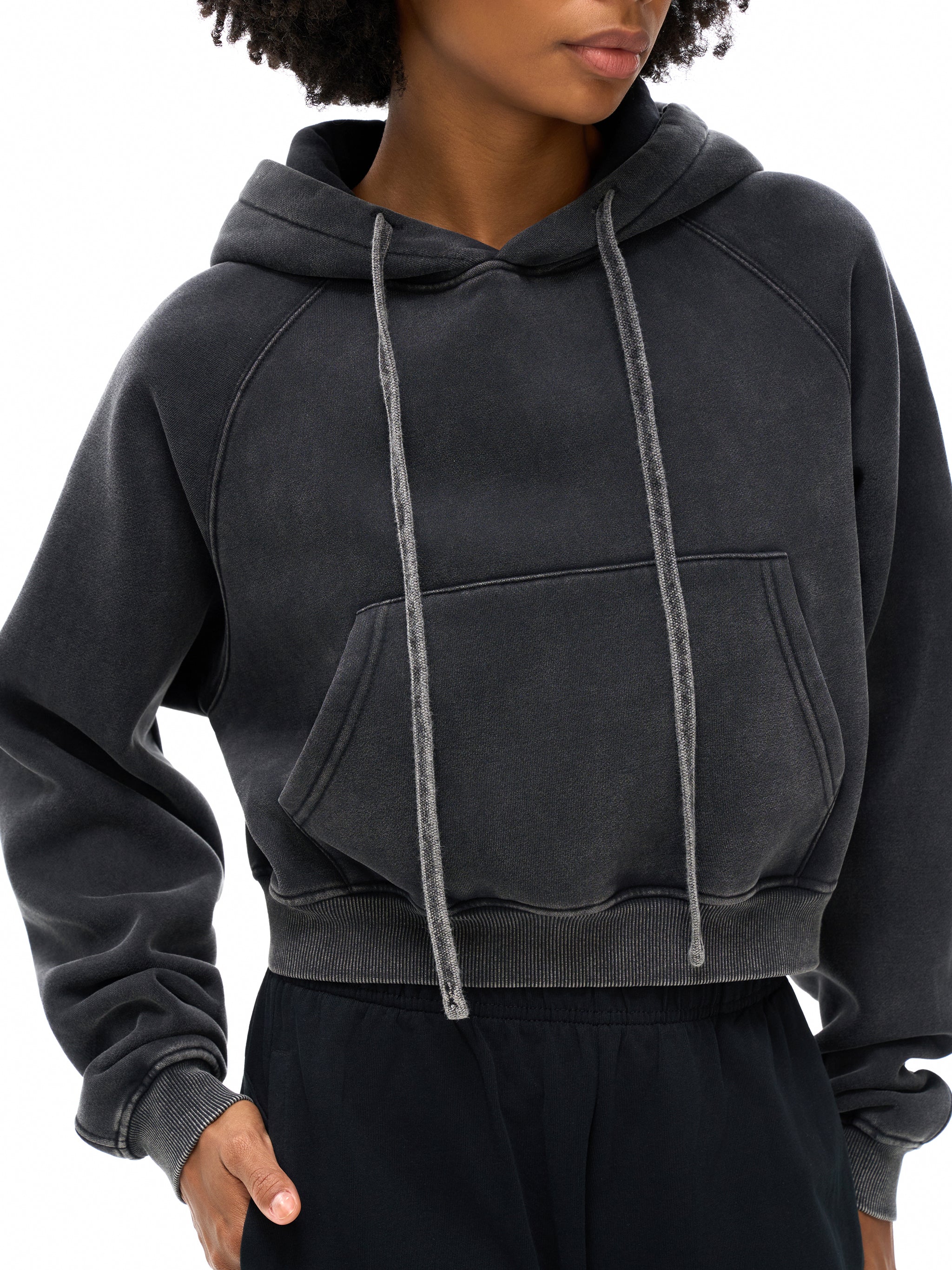 Person wearing a dark gray hoodie with a white background