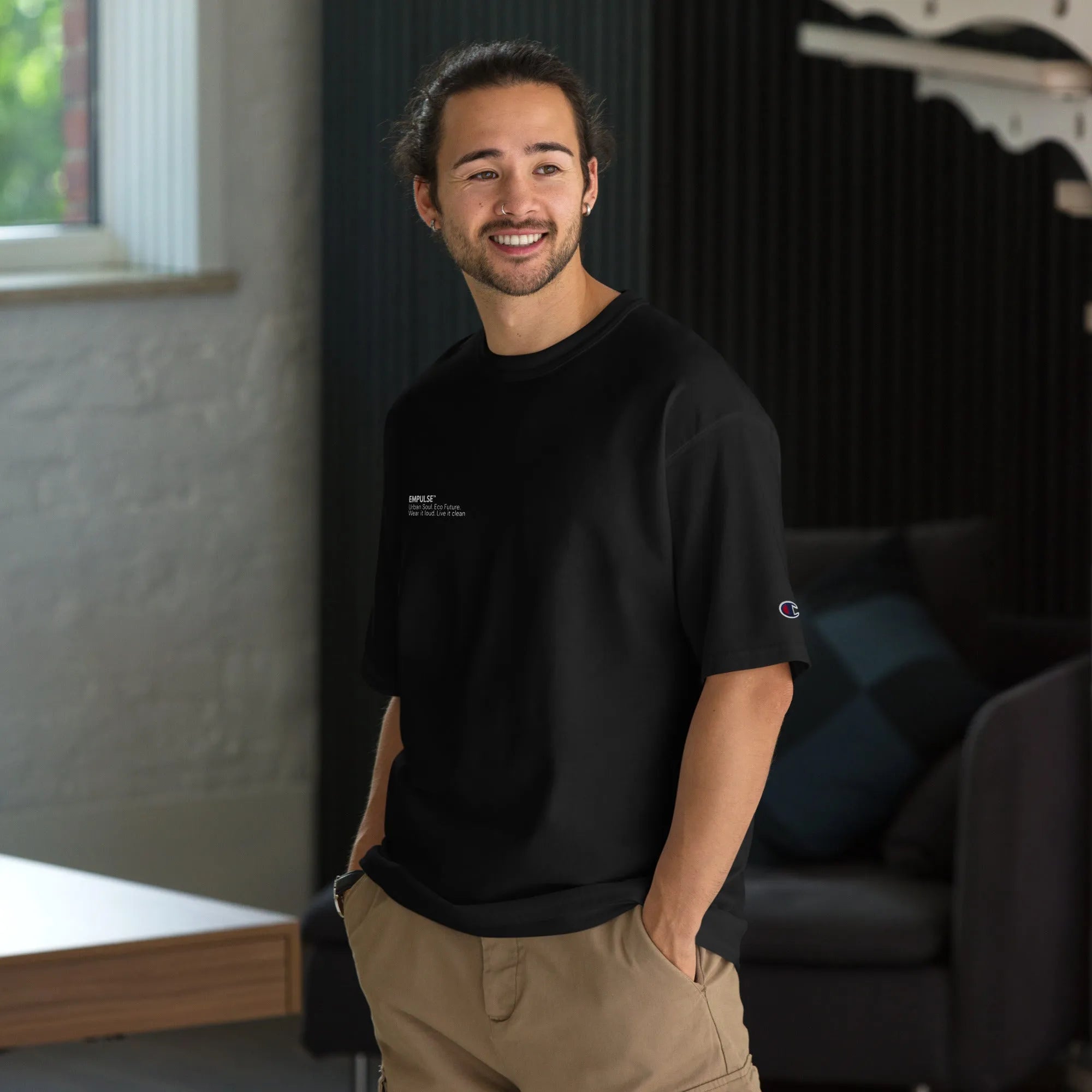 Men's Champion black t-shirt worn by model standing front-facing indoors
