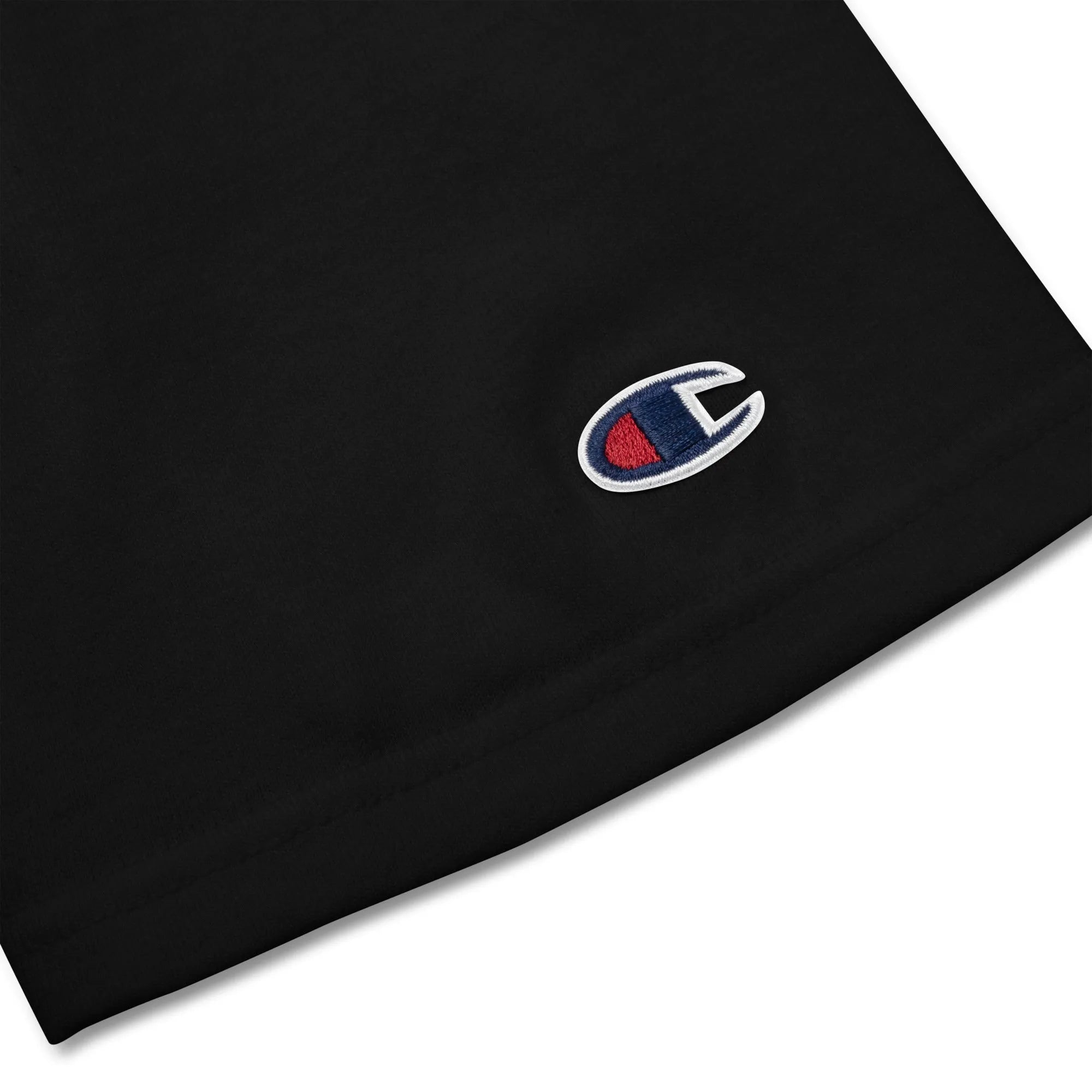 Close-up of Champion “C” logo patch embroidered on black t-shirt sleeve