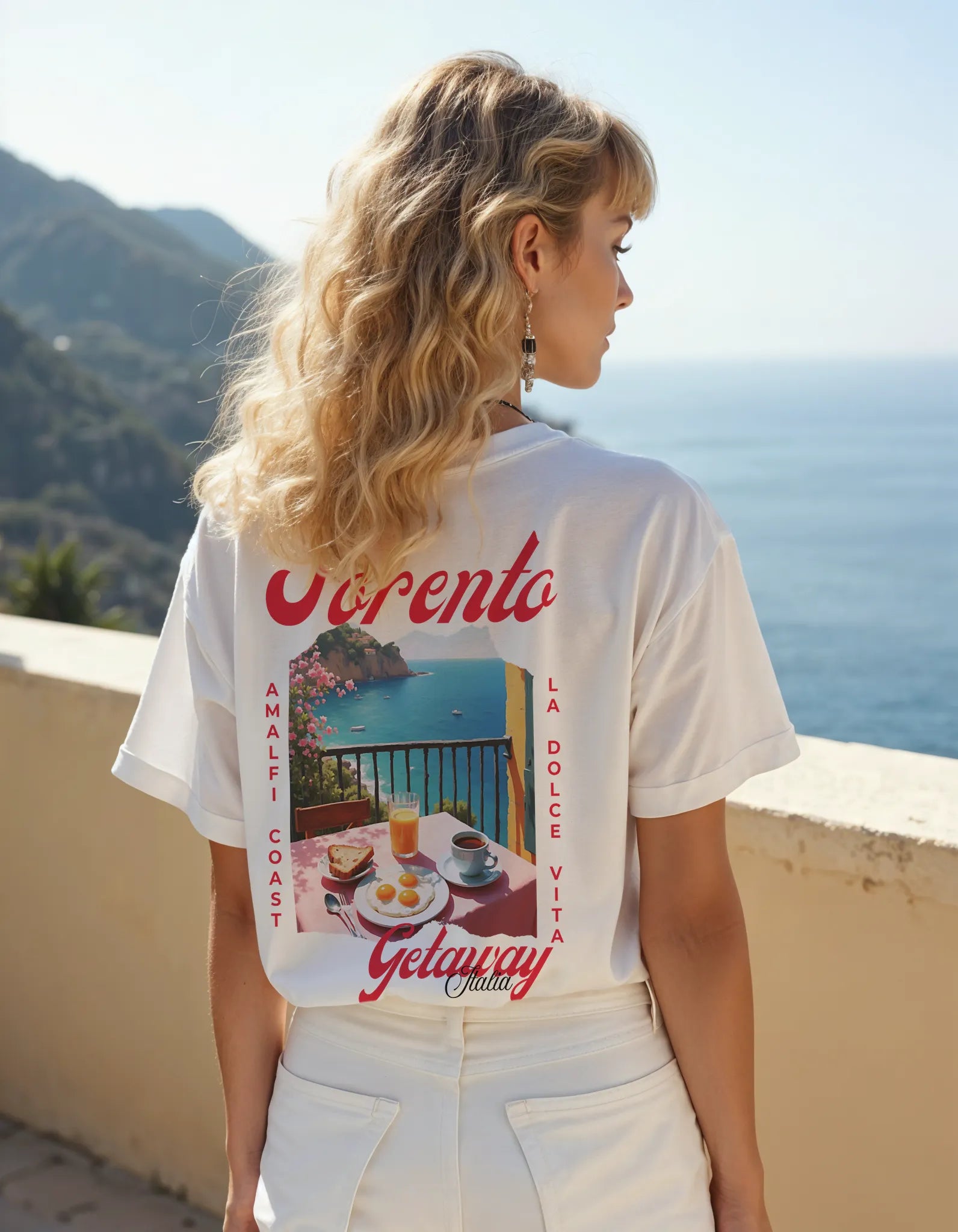 Empulse™ Amalfi Sorona tee worn by female model standing near the coast, showcasing back artwork