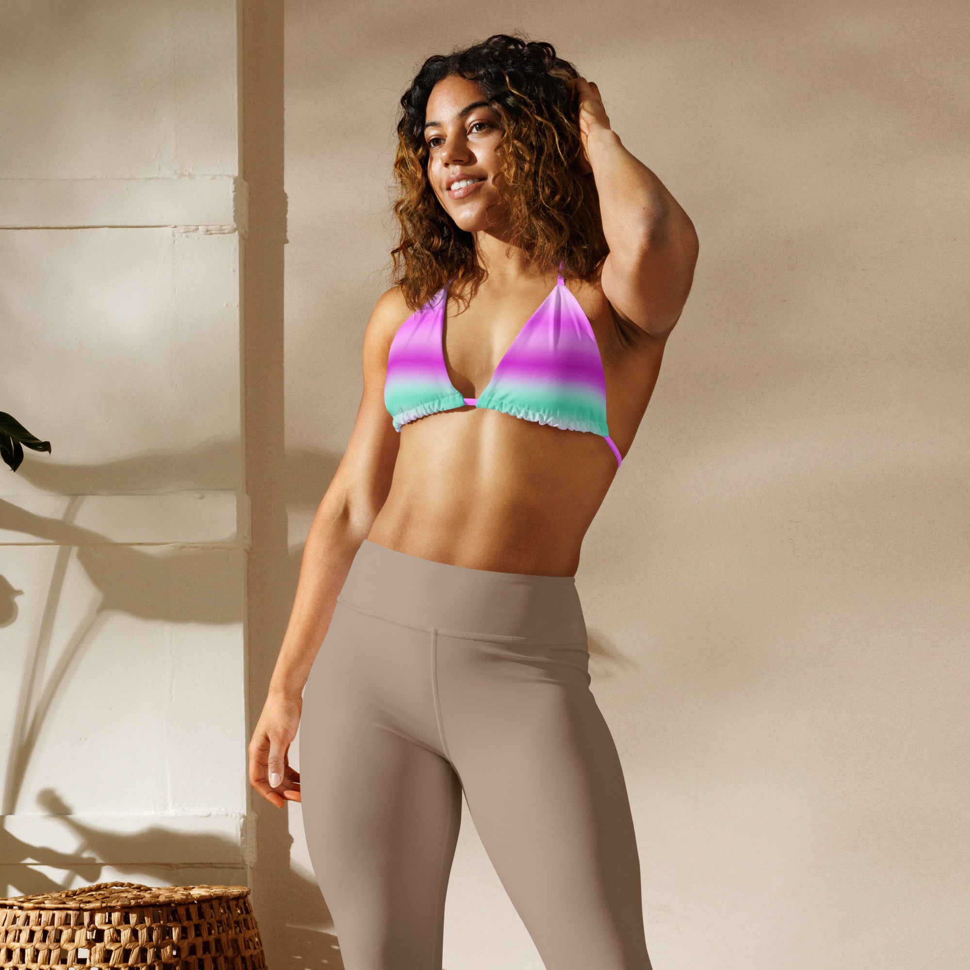 Woman lounging in full Empulse™ cotton candy striped bikini set