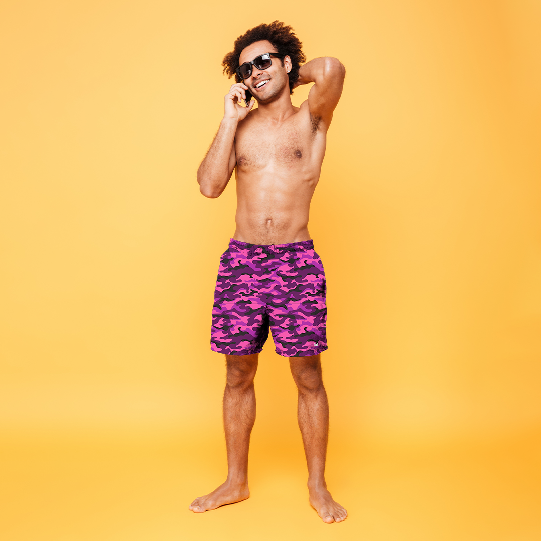 Model wearing Empulse™ Blush Camouflage shorts with sunglasses in front of yellow wall