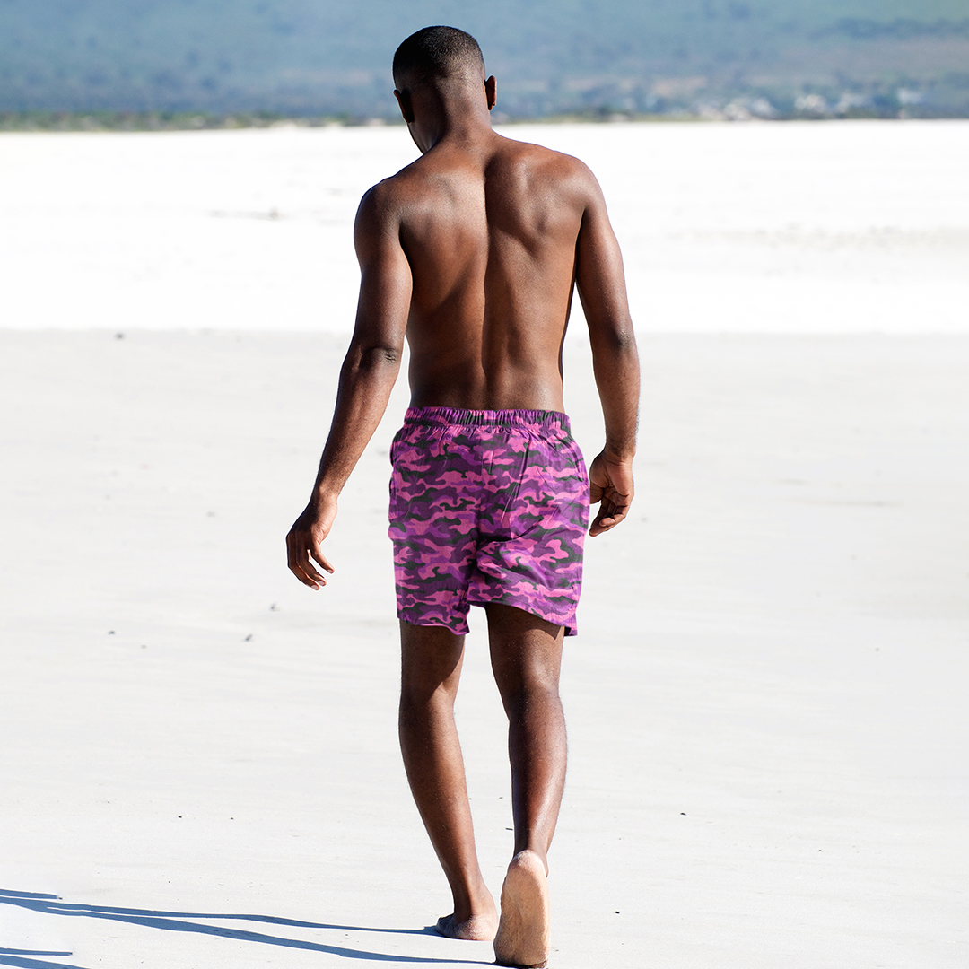 Rear view of Empulse™ Blush Camouflage shorts worn barefoot by model on sandy beach