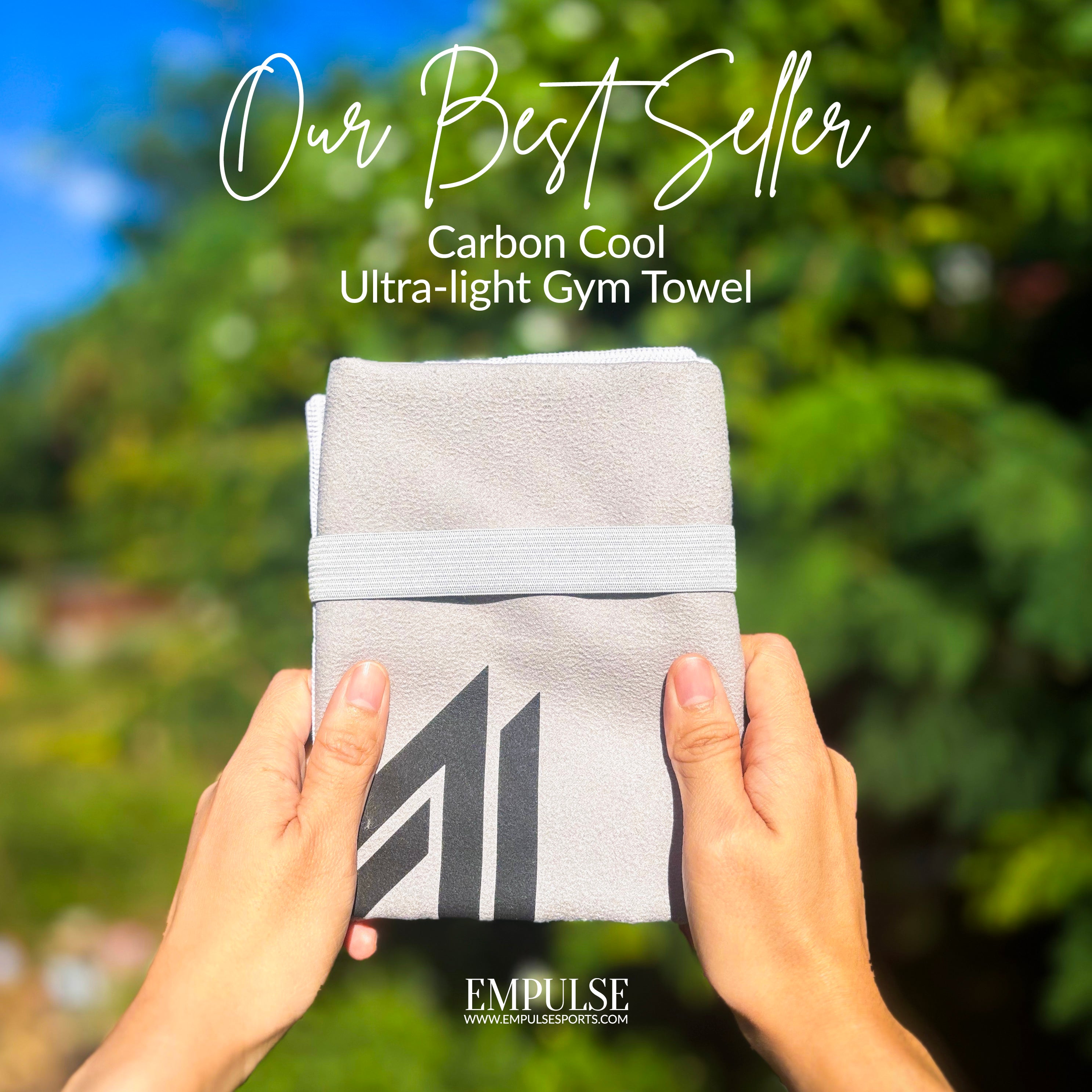 Empulse™ Carbon Cool towel folded with label shown in lush outdoor greenery