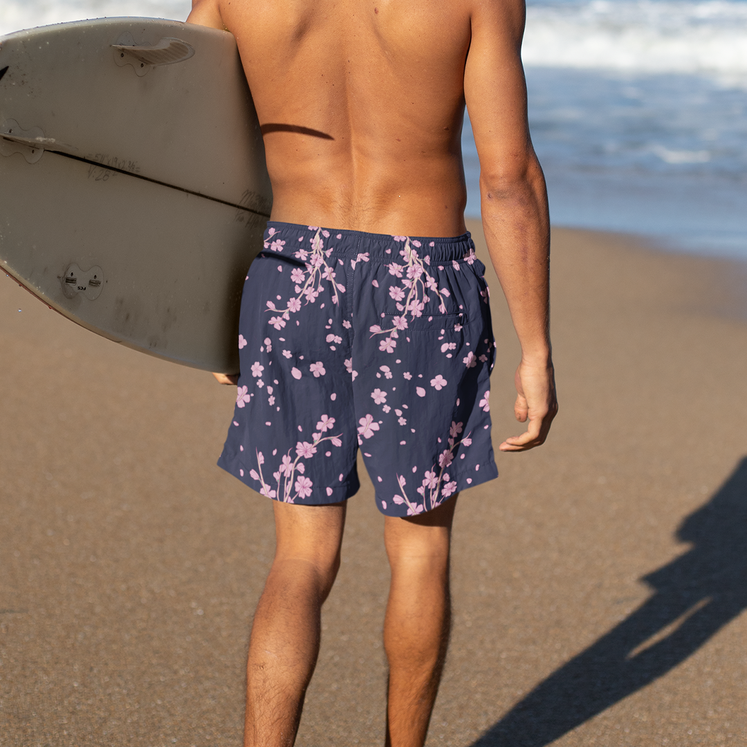 Rear view of Empulse™ Cherry Blossom swim shorts worn walking along sandy shore