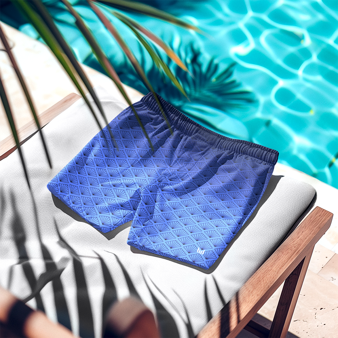 Empulse™ Daylight Bloom swim shorts laid out on lounge chair beside pool