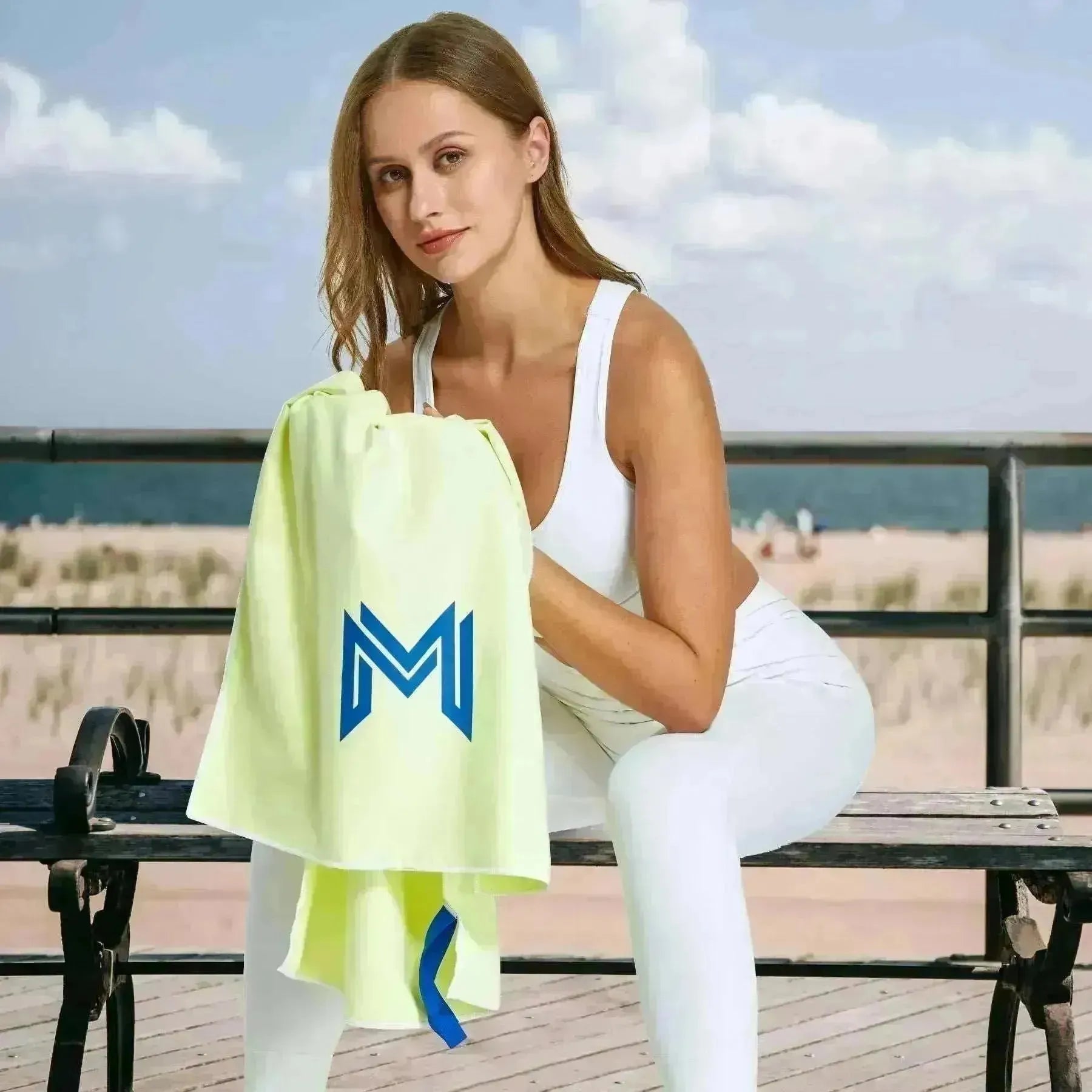 Empulse™ Lemon Zest towel worn by female model in white activewear seated outdoors