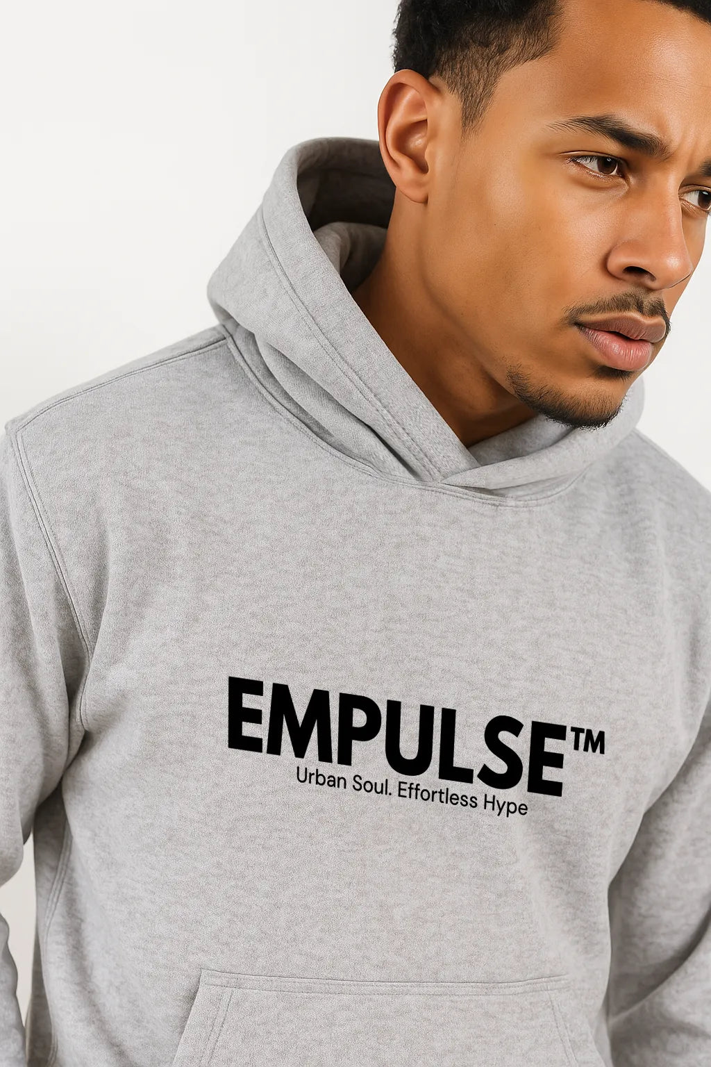 Casual seated man in grey Empulse™ hoodie, lifestyle image on industrial concrete background