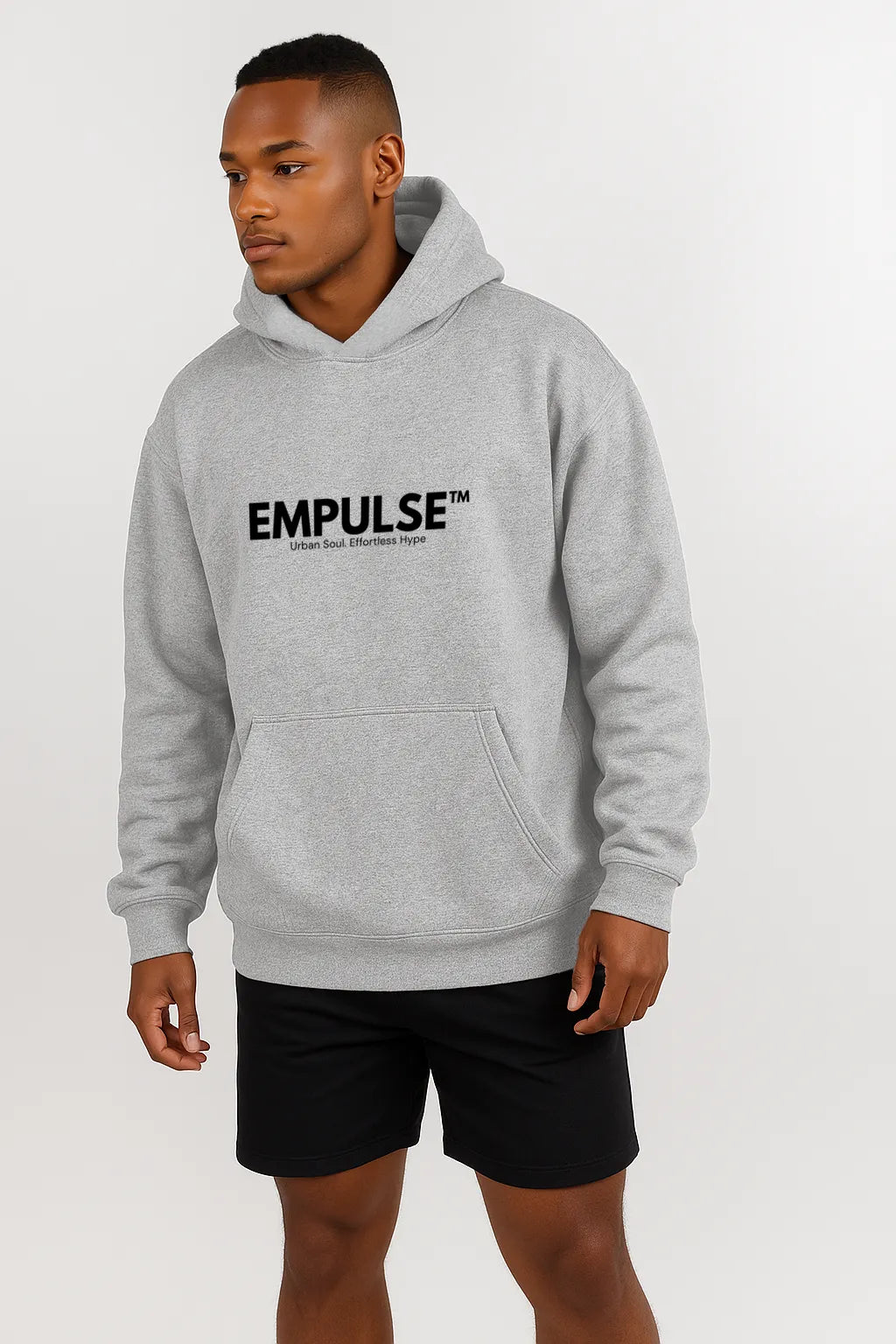 Male model standing in Empulse™ ash grey hoodie with bold black logo, front studio view