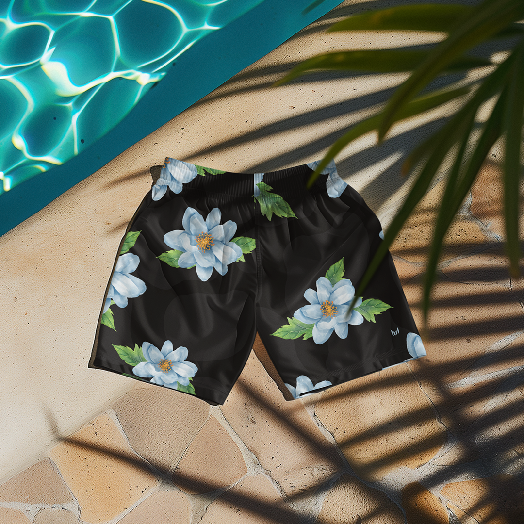 Flat lay of Empulse™ Orchids shorts on a striped pool chair beneath palm leaf shadows