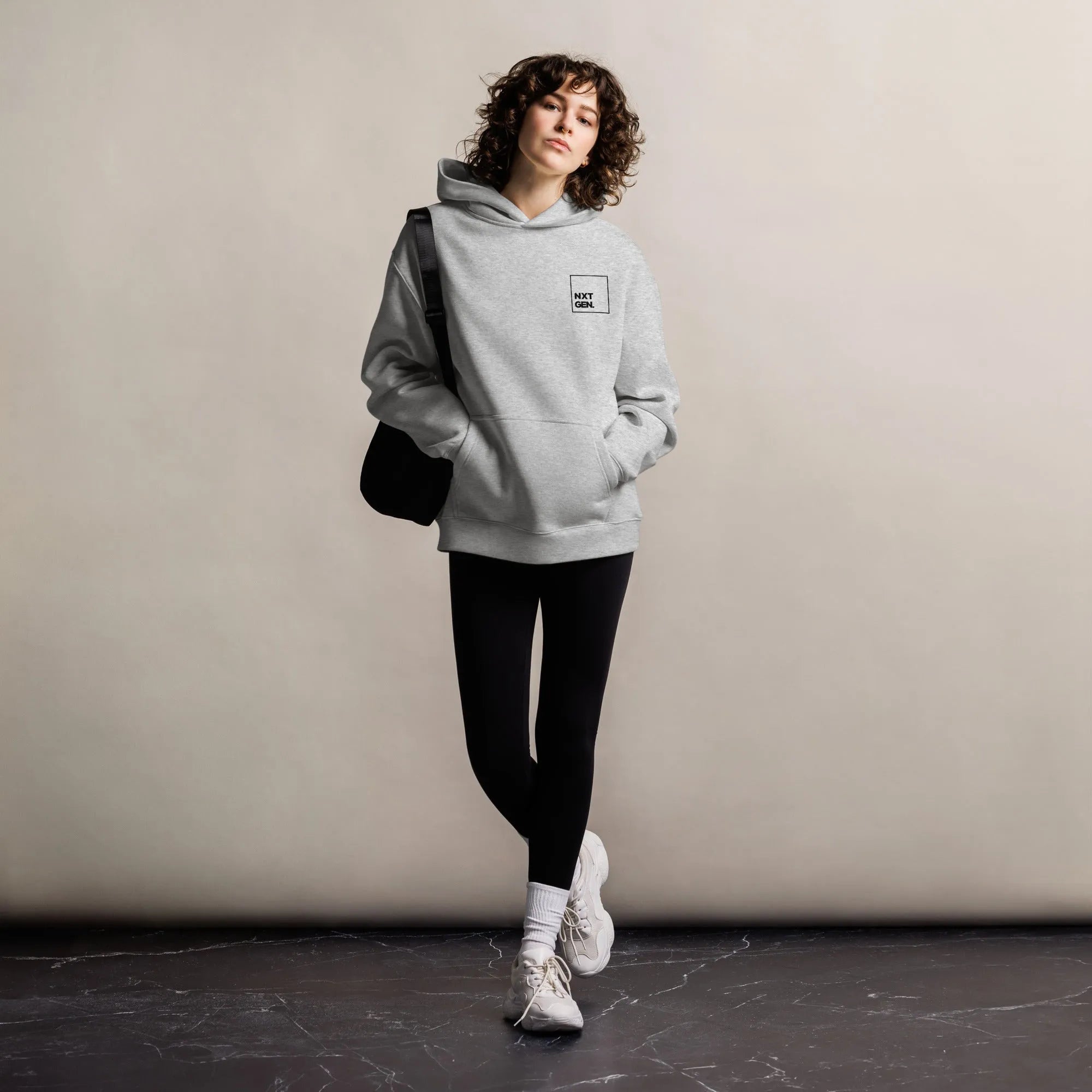 Empulse™ oversized grey hoodie styled by female model in relaxed standing pose

