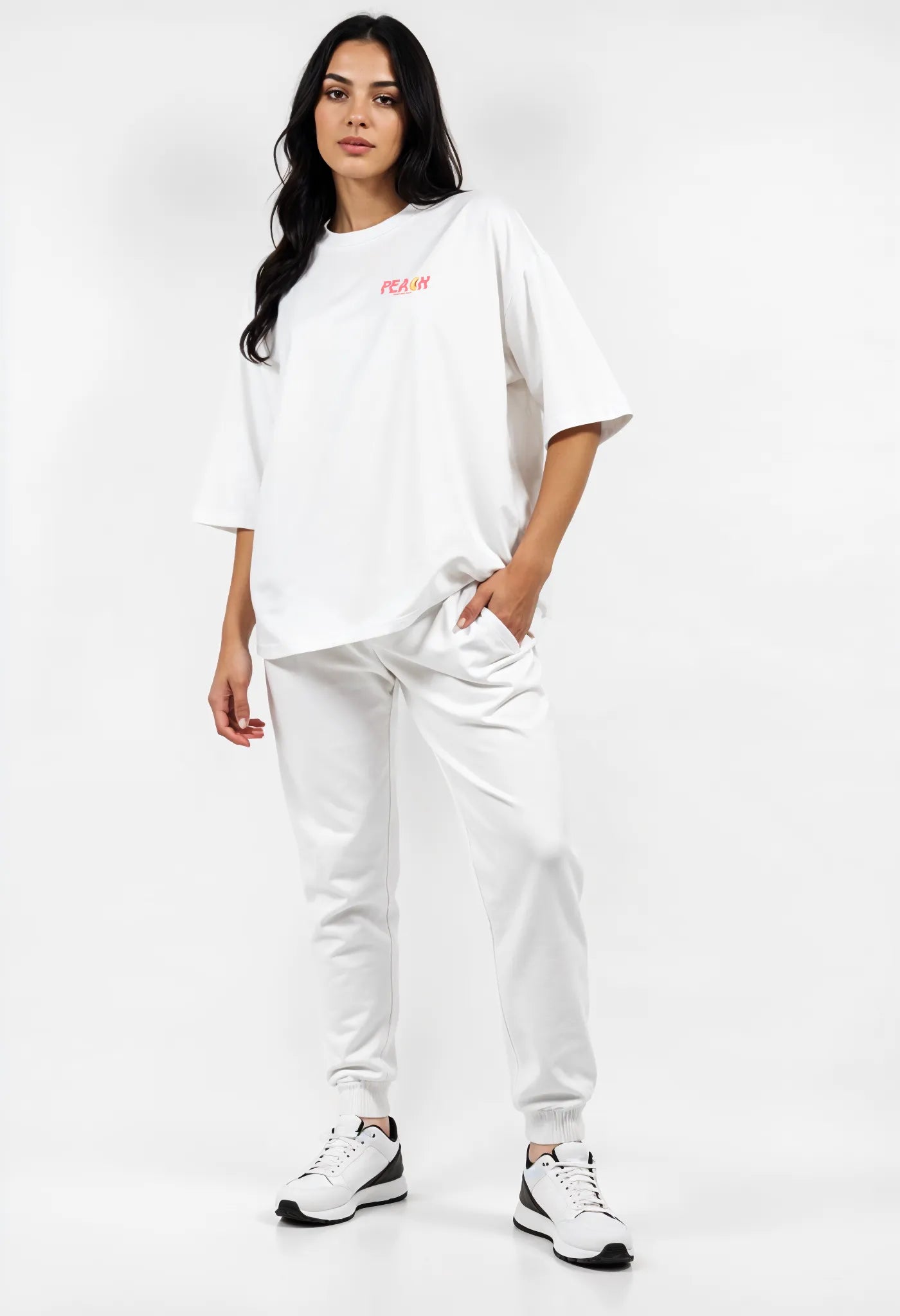 Empulse™ Sorona tee in white with peach logo styled by female model in streetwear outfit